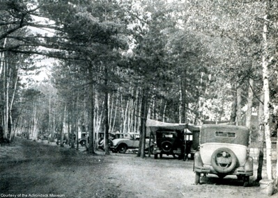 Cars parked in Adirondack campground, late 1920s