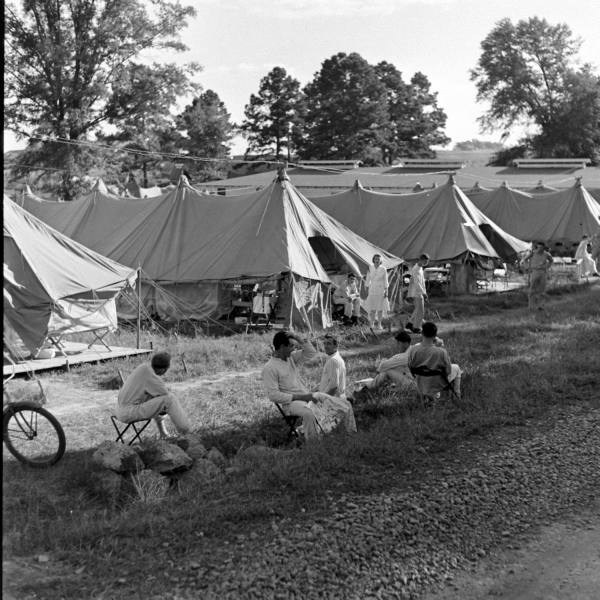 Organized tent camp with rows of canvas tents and a bicycle